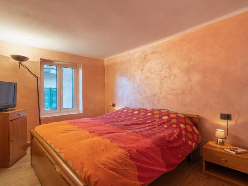 ヴェンティミリアにあるApartment Ernestina by Interhomeのベッドルーム1室(オレンジ色の掛け布団、窓付)
