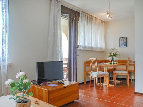 ein Wohnzimmer mit einem TV und einem Esszimmer in der Unterkunft Apartment Bellavista-24 by Interhome in Cademario