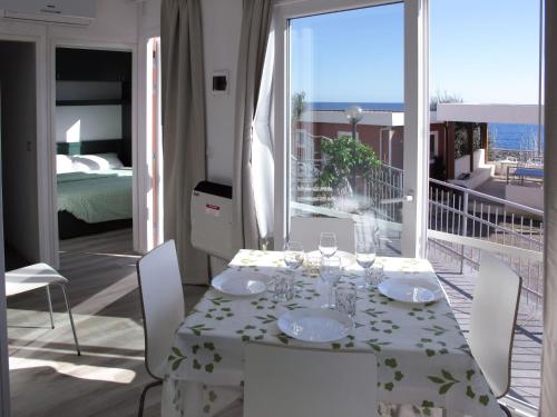 een eetkamer met een tafel en een balkon bij Holiday Home Gelsomino - SLR403 by Interhome in San Lorenzo al Mare