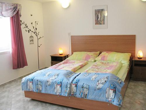 ein Schlafzimmer mit einem Bett und zwei Nachttischen mit Lampen in der Unterkunft Holiday Home Annemarie - ALD317 by Interhome in Balatonalmádi