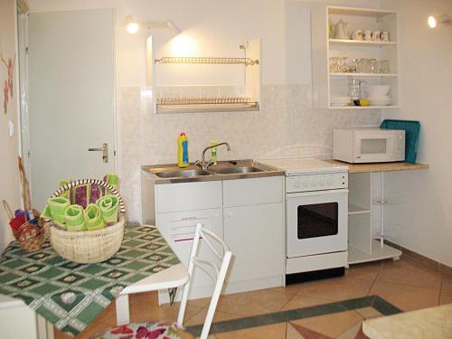 eine Küche mit einem Waschbecken und einem Tisch mit einem Tisch in der Unterkunft Holiday Home Annemarie - ALD317 by Interhome in Balatonalmádi