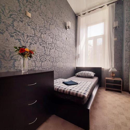 a bedroom with a bed and a vase of flowers at Хостел Арбат 29 in Moscow