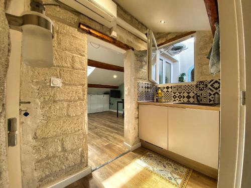 Cette chambre dispose d'un mur en pierre et d'une cuisine. dans l'établissement # CLIM - TRAM - Centre ville - Sous les toits #, à Montpellier