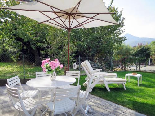 a white table and chairs with a white umbrella at Holiday Home Anna by Interhome in Luino