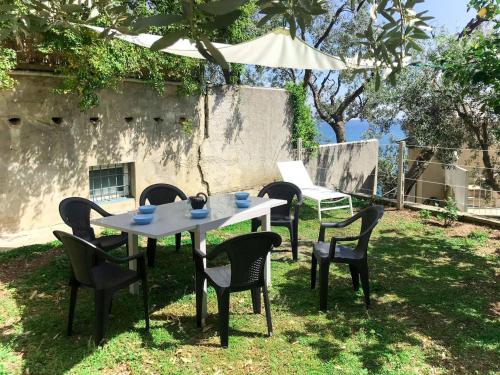 a table and chairs in a yard with a table at Holiday Home Giorgia - BGB100 by Interhome in Bergeggi