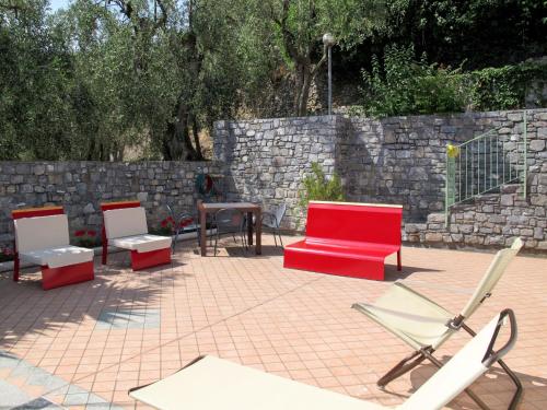 a patio with three chairs and a red couch at Holiday Home Innovativa by Interhome in Stellanello