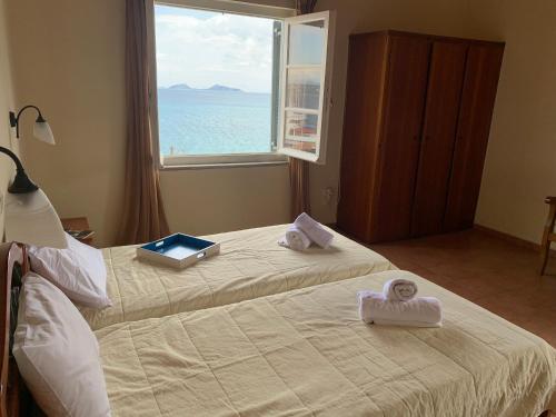 a bedroom with a bed with towels and a window at A Hotel Faros in Spetses