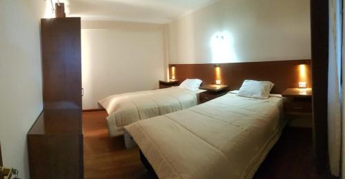 a hotel room with two beds and two lamps at Asian House in Uyuni