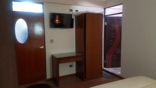 um quarto com um closet, uma televisão e um espelho em Asian House em Uyuni