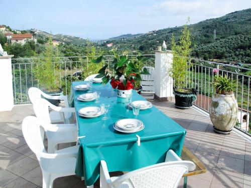 una mesa azul con sillas blancas en el balcón en Apartment Daniela - DOL295 by Interhome, en Dolcedo