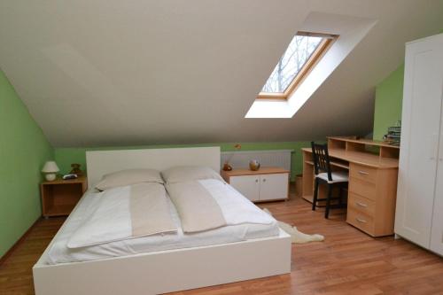 a bedroom with a bed and a desk and a window at fewo1846 - Ueber der Foerde - komfortables Reihenhaus mit Garten und Carport in Flensburg