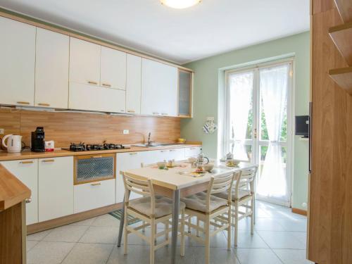 kuchnia z białymi szafkami oraz stołem i krzesłami w obiekcie Holiday Home Gaia by Interhome w mieście Bellano
