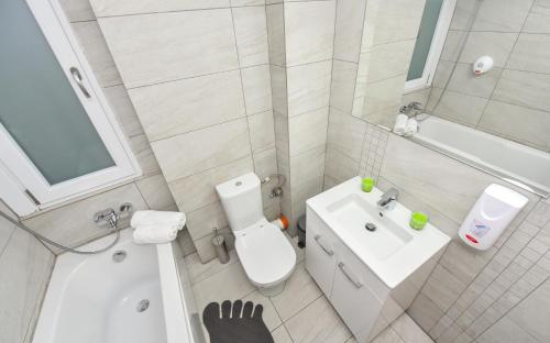 a white bathroom with a toilet and a sink at Bucharest Accommodation Apartments in Bucharest