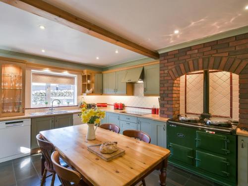 a kitchen with a wooden table and some chairs at Browside in Coniston
