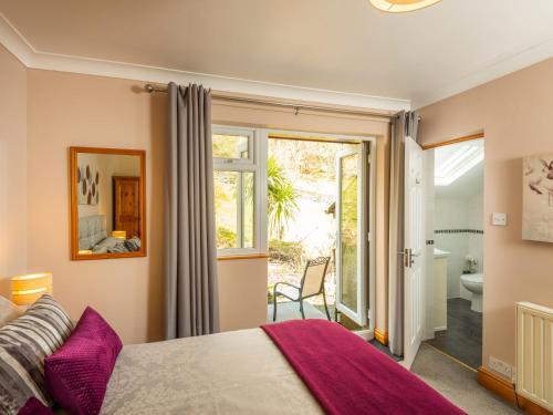 a bedroom with a bed and a window and a bathroom at Browside in Coniston