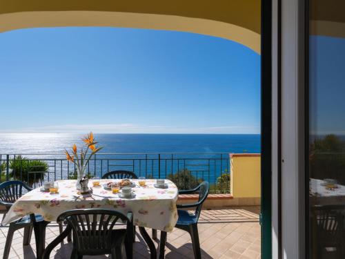 een tafel op een balkon met uitzicht op de oceaan bij Apartment Primavera - PGI130 by Interhome in Poggi