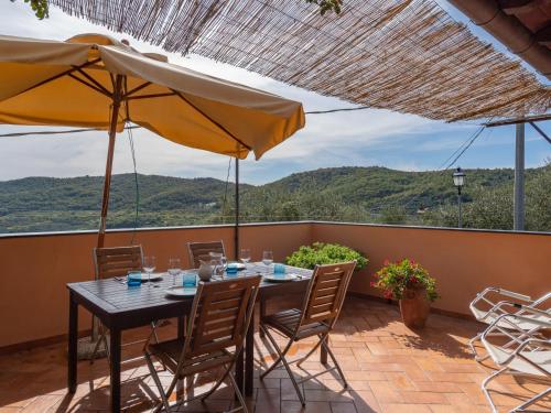 Holiday Home U Figu du Camin by Interhome في Villa Viani: طاولة مع كراسي ومظلة على الفناء