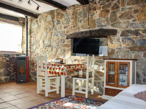 Habitación con pared de piedra, mesa y TV. en Apartment Potes Vinon - Cabaña by Interhome, en Tama