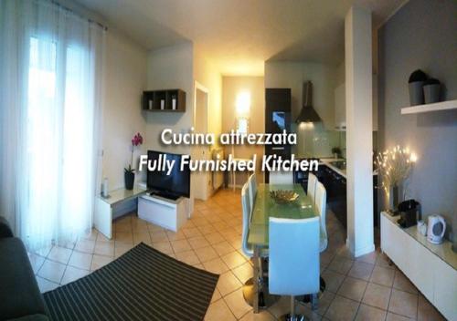 a living room with a table and a kitchen at Casa Bonotto in Desenzano del Garda