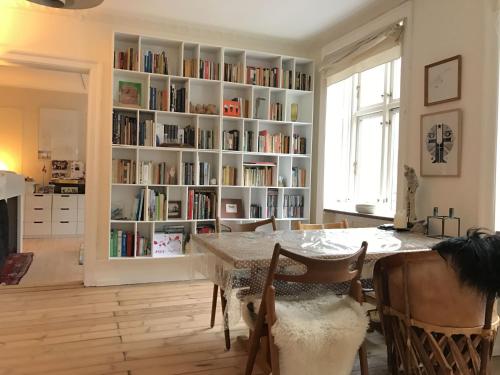 una sala de estar con una mesa y una estantería llena de libros. en ApartmentInCopenhagen Apartment 1107, en Copenhague