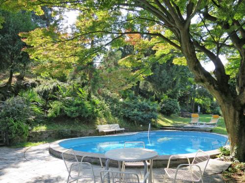 波爾托瓦爾特拉瓦利亞的住宿－Holiday Home Bramati by Interhome，树旁带桌椅的游泳池