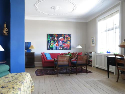a living room with a red couch and chairs at ApartmentInCopenhagen Apartment 1150 in Copenhagen