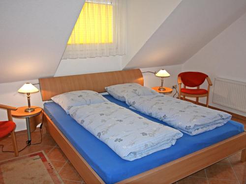 1 dormitorio con 1 cama con sábanas azules y 2 sillas en Apartment Lemke by Interhome, en Prerow