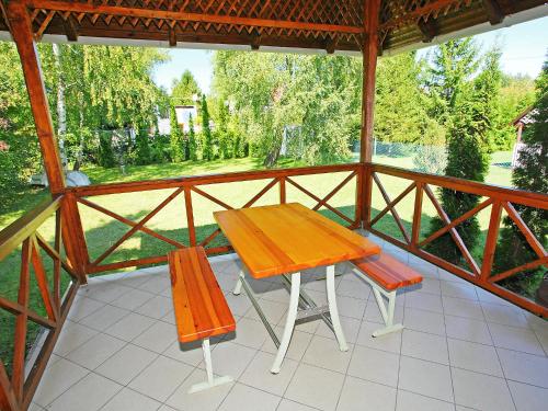 uma mesa de madeira e duas cadeiras num alpendre em Holiday Home Maria by Interhome em Balatonmáriafürdő