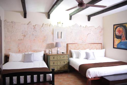 a bedroom with two beds and a dresser at Mansion Colonial Boutique Hotel Pool Jacuzzi Bar Restaurant by BTC Group Crypto in Santo Domingo