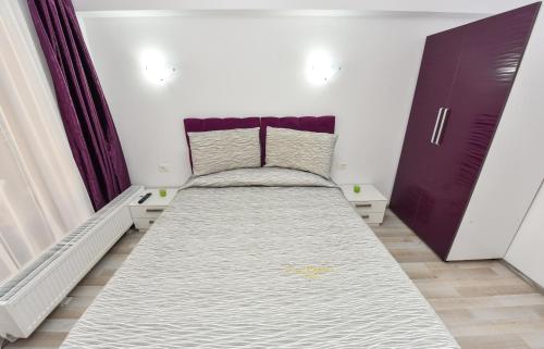 a small bedroom with a bed and a purple cabinet at Bucharest Accommodation Apartments in Bucharest
