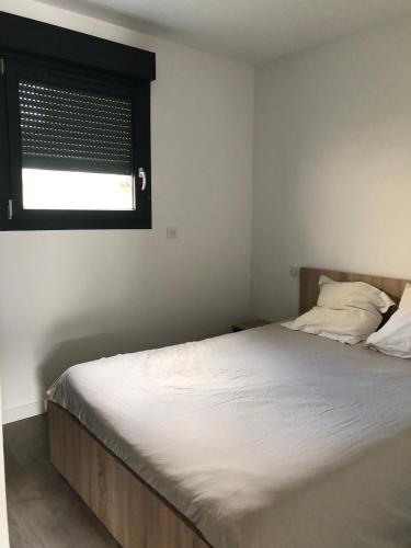 - une chambre avec un lit doté d'une fenêtre et d'un couvre-lit blanc dans l'établissement LA CASA DE FRANCOIS, à Oraison