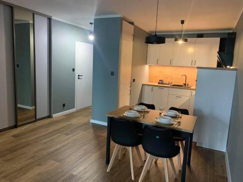 a kitchen with a table and chairs in a room at Apartament Wiosełko Warszawa in Warsaw