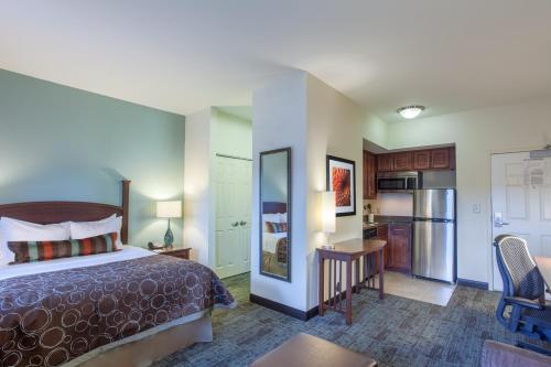 a hotel room with a bed and a kitchen at Staybridge Suites North Brunswick, an IHG Hotel in North Brunswick