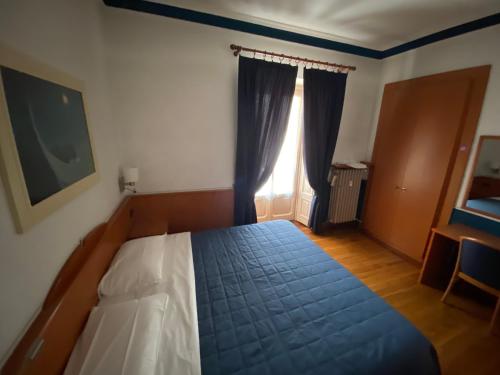 a bedroom with a bed with a blue bedspread and a window at Artua'&Solferino in Turin