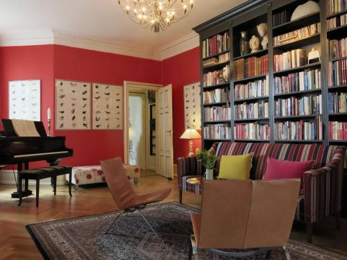 a living room with red walls and a piano at ApartmentInCopenhagen Apartment 1290 in Copenhagen