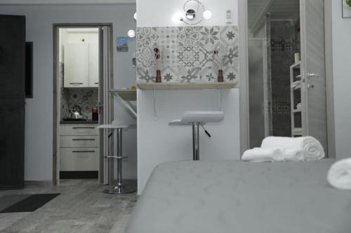a white room with a bed and a kitchen at Sicily house in Catania