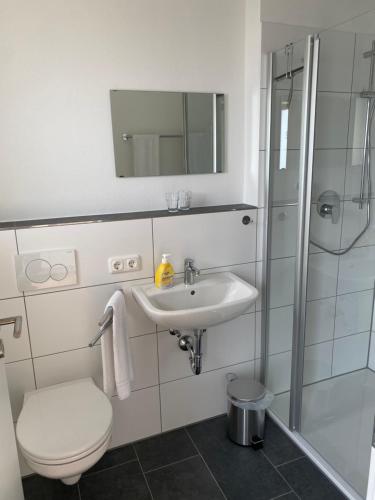 a bathroom with a toilet and a sink and a shower at Boardinghouse37 in Schwarzach