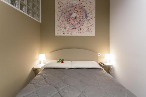 a bedroom with a large bed with two lamps at HH Hermoso Housing ALESSANDRIA in Alessandria