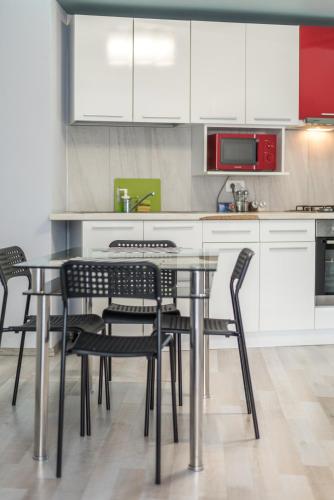 a kitchen with a table with chairs and white cabinets at Bucharest Accommodation Apartments in Bucharest