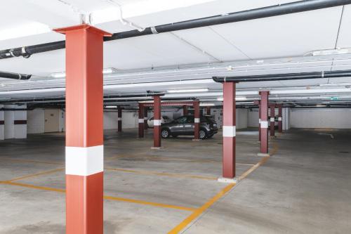 a parking lot with red and white poles and a car at Hotel Borgo Brianteo in Ponte San Pietro