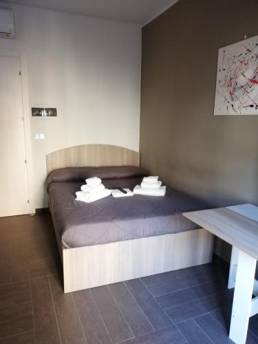 a bedroom with a bed with towels on it at HH Hermoso Housing ALESSANDRIA in Alessandria