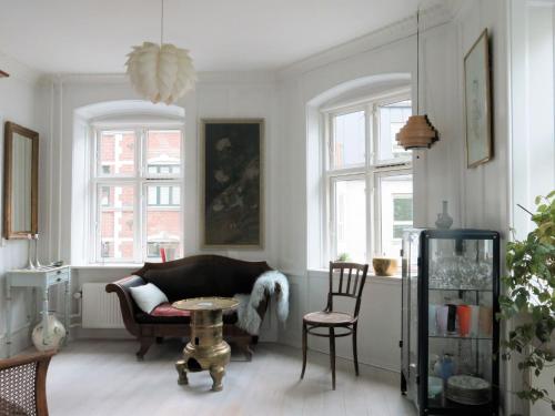 a living room with a couch and a table and chairs at ApartmentInCopenhagen Apartment 1389 in Copenhagen