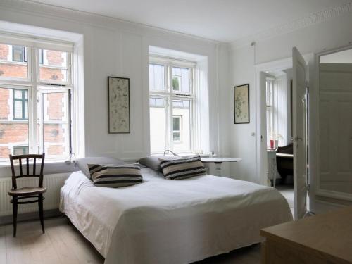 a white bedroom with a bed with two pillows on it at ApartmentInCopenhagen Apartment 1389 in Copenhagen