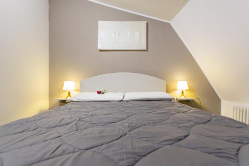 a bedroom with a large bed with two lamps at HH Hermoso Housing ALESSANDRIA in Alessandria