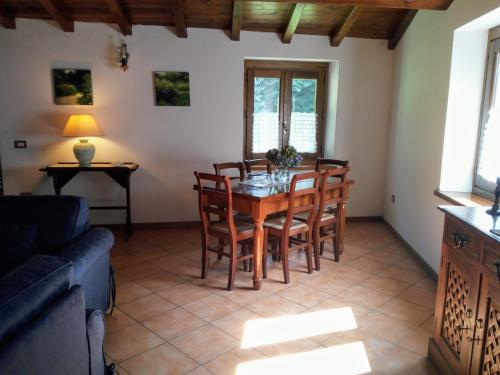 salon ze stołem, krzesłami i kanapą w obiekcie Agriturismo il canale w mieście Corfino