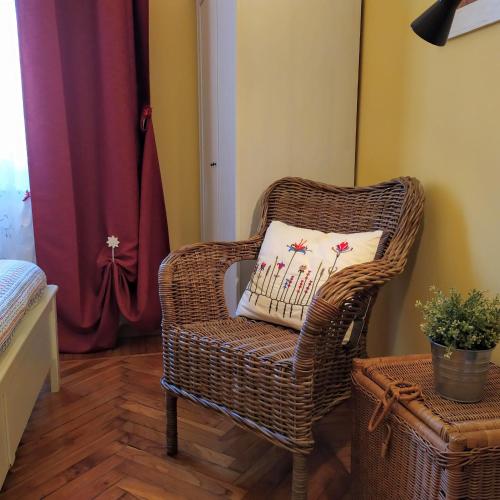 a wicker chair with a pillow in a room at Alma Clara B&B in Turin