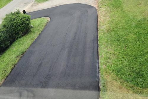 a black road with grass on the side of it at The Dragon's Den 5 bedroom house 1 mile to Main St in Tazewell