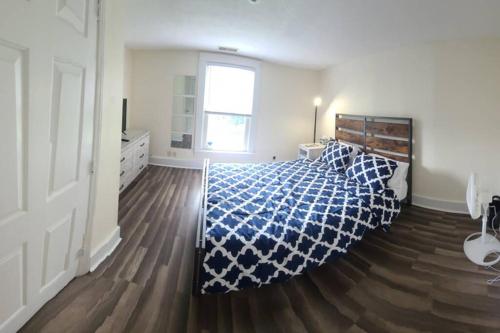 a bedroom with a bed with a blue and white comforter at The Dragon's Den 5 bedroom house 1 mile to Main St in Tazewell