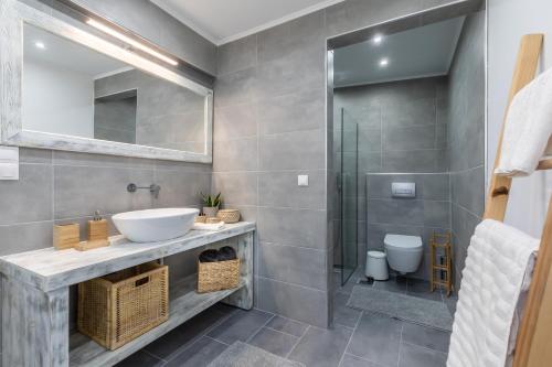 een badkamer met een wastafel en een douche bij Sea Senses Apartment in Skopelos Town