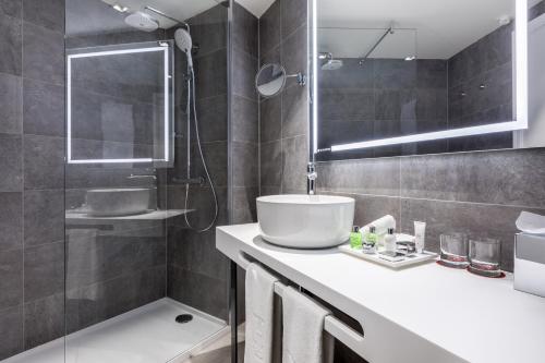 a bathroom with a sink and a shower at NH Collection Brussels Grand Sablon in Brussels